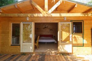 Una pequeña casa de madera con una cama. en CABANE BAMBOU en Fronsac