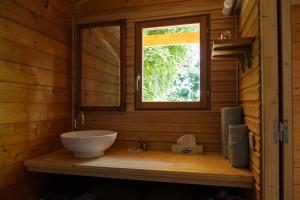 a bathroom with a bowl sink and a window at CABANE BAMBOU in Fronsac