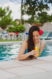 una chica en una piscina sosteniendo una bebida en Rioma Hotel en Malargüe