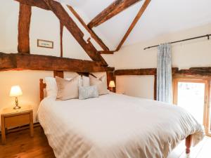 ein Schlafzimmer mit einem großen weißen Bett und einem Fenster in der Unterkunft Tippets View in Pembridge