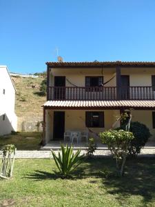 a house with two tables and chairs in a yard at Arraial do Cabo in Arraial do Cabo