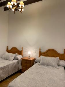 1 dormitorio con 2 camas y mesita de noche con lámpara en Casa Boneta Alpujarra Almeria-Alboloduy, en Almería