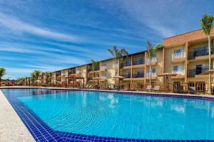 una gran piscina frente a un hotel en Apartamento Ondas Praia Resort en Porto Seguro