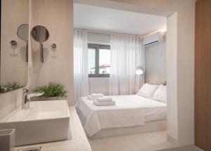 a white bedroom with a bed and a sink at Beach Bird (Sandpiper) 140m2 Chalkidiki Greece in Kalives Poligirou