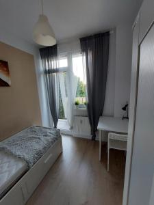 a bedroom with a bed and a desk and a window at Pokoje Gdańsk Oliwa - Mściwoja II 50, do morza 1,9km, 750m SKM Oliwa, 1,1km Park Oliwski in Gdańsk +15 photos