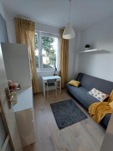 a living room with a blue couch and a window at Pokoje Gdańsk Oliwa - Mściwoja II 50, do morza 1,9km, 750m SKM Oliwa, 1,1km Park Oliwski in Gdańsk
