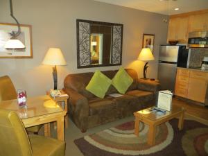 ein Wohnzimmer mit einem braunen Sofa und grünen Kissen in der Unterkunft Stardust Lodge in South Lake Tahoe