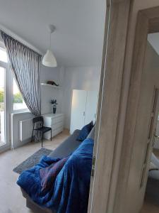 a bedroom with a bed with a blue blanket at Pokoje Gdańsk Oliwa - Mściwoja II 50, do morza 1,9km, 750m SKM Oliwa, 1,1km Park Oliwski in Gdańsk
