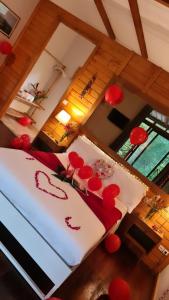 a bedroom with a bed with red decorations on it at Eden Valley Ecolodge and Farming in Madalena