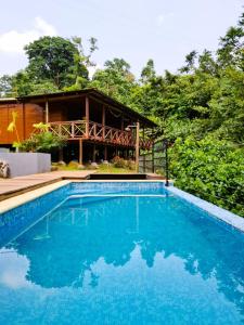 a swimming pool in front of a house at Eden Valley Ecolodge and Farming in Madalena