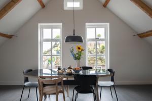 uma sala de jantar com uma mesa de vidro e cadeiras em Schitterend appartement in dorpsstraat Langweer! em Langweer