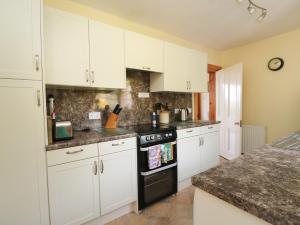 a kitchen with white cabinets and a black oven at Drover's Way in Newyork