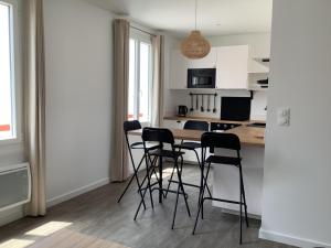 eine Küche mit einem Tisch und Stühlen im Zimmer in der Unterkunft Trinquet Bordatxo in Saint-Jean-de-Luz