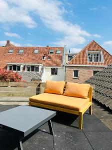 a yellow couch sitting on top of a roof at Canal apartment at historic CityCenter Amersfoort in Amersfoort +44 photos