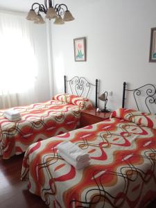 een slaapkamer met 2 bedden en rode en witte dekens bij Puente Villanueva dreans in Medina de Pomar