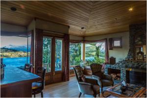 a living room with a table and chairs and windows at Pencarrow Boutique Lodge in Queenstown