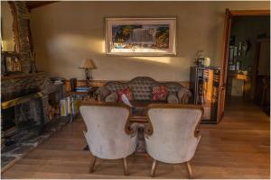 a living room with a couch and a table and chairs at Pencarrow Boutique Lodge in Queenstown