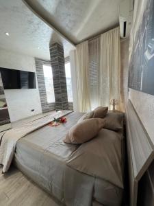 een slaapkamer met een groot bed met kussens erop bij Suite samì in Catania