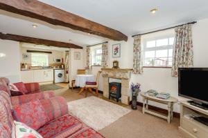 a living room with a couch and a fireplace at Fir Tree Stables in Summer Bridge