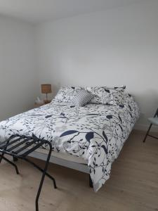 a bedroom with a bed with a black and white comforter at Gîte du 149 route de la Mer in Sainte-Flavie