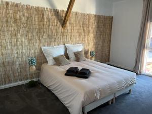 a white bed with two black towels on it at Gite les Zozios du lac du Der in Hauteville