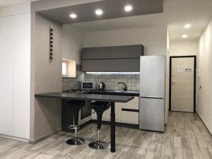 a kitchen with a black counter and a refrigerator at Sunrise Beach Apartment Trapani in Trapani