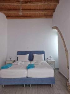 Una cama azul y blanca en una habitación en John Akroyiali en Loutro
