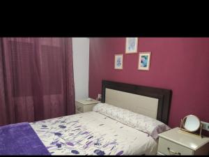 1 dormitorio con cama y pared de color rosa en Andrevia del carmen, en Moratalla