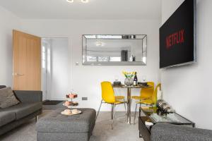 a living room with a table and yellow chairs at Butterfly House - Luxury 2 Bedroom Property in Kettering
