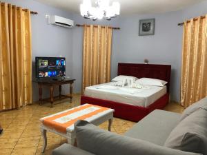 een woonkamer met 2 bedden en een bank bij Studios&Apartment Niko Luka in Ksamil