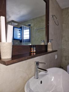 a bathroom with a sink and a mirror at John Akroyiali in Loutro +46 photos