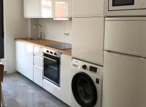 a kitchen with a washing machine and a refrigerator at Apartamento Playa da Corna in San Pedro