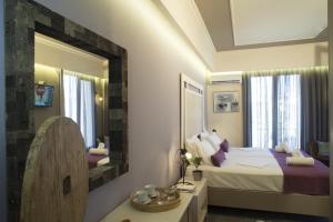 una camera d'albergo con letto e specchio di Elia Potie a Chania