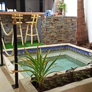 a small swimming pool with two chairs and a table at Rocco Hotel Bed & Breakfast in Cartagena de Indias