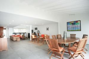 a dining room and living room with a table and chairs at Villa Liléa in Saint-François