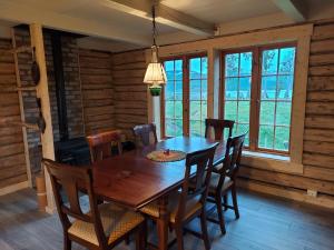 a dining room with a wooden table and chairs at Villmarksgård tømmerstue in Hattfjelldal +12 photos