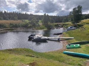 a group of boats parked on a river at Villmarksgård tømmerstue in Hattfjelldal