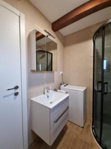 a bathroom with a white sink and a mirror at Holiday house Adriana in Povljana