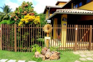 a fence with rocks in front of a house at Madalena Apart in Praia do Forte