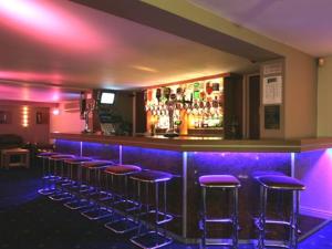 a bar with purple bar stools in a room at Dutchman Hotel in Blackpool +6 photos