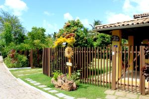 a wooden fence in front of a house at Madalena Apart in Praia do Forte