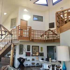 sala de estar con mesa y escaleras de madera en Vineyard View Dome House, en Paso Robles