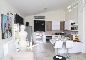 a kitchen and a living room with a table at CozyLuxuryApartment in Keramoti