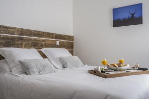 a white bed with a tray of food on it at La Tissandière in Lalbenque
