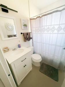 a white bathroom with a toilet and a sink at Pet Friendly! Private Casita in Nob Hill in Albuquerque
