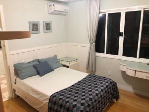 1 dormitorio con cama y ventana en FamilyHome, en Florianópolis