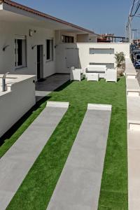 a patio with grass and white furniture on a house at AL BAYDA in Palermo