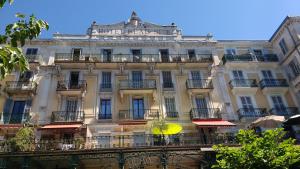 um grande edifício com varandas e um sinal nele em Le Beau Site Grand Hotel - lovely heritage cocoon Aix-les-Bains central park em Aix-les-Bains