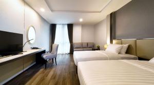 a hotel room with two beds and a television at SureStay Plus by Best Western Sukhumvit 2 in Bangkok +112 photos