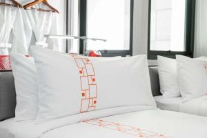 a white bed with white pillows in a room with windows at Vib Best Western Sanam Pao in Bangkok +80 photos
